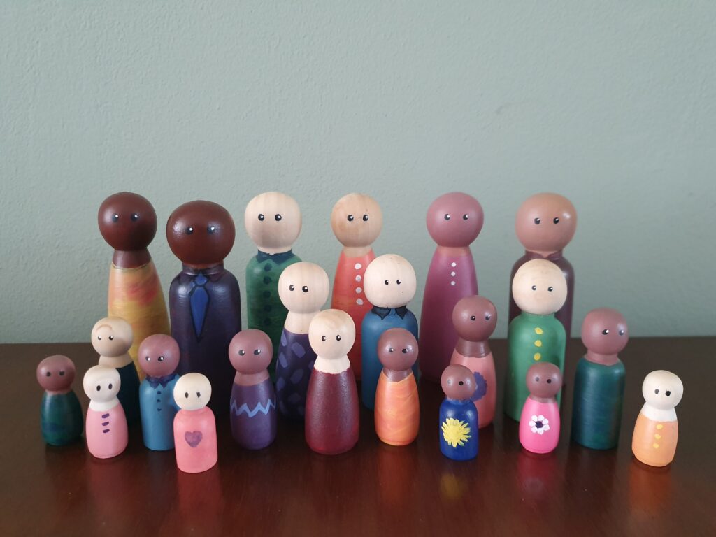 Poppetjes met verschillende huidskleuren en leeftijden als familie bij elkaar