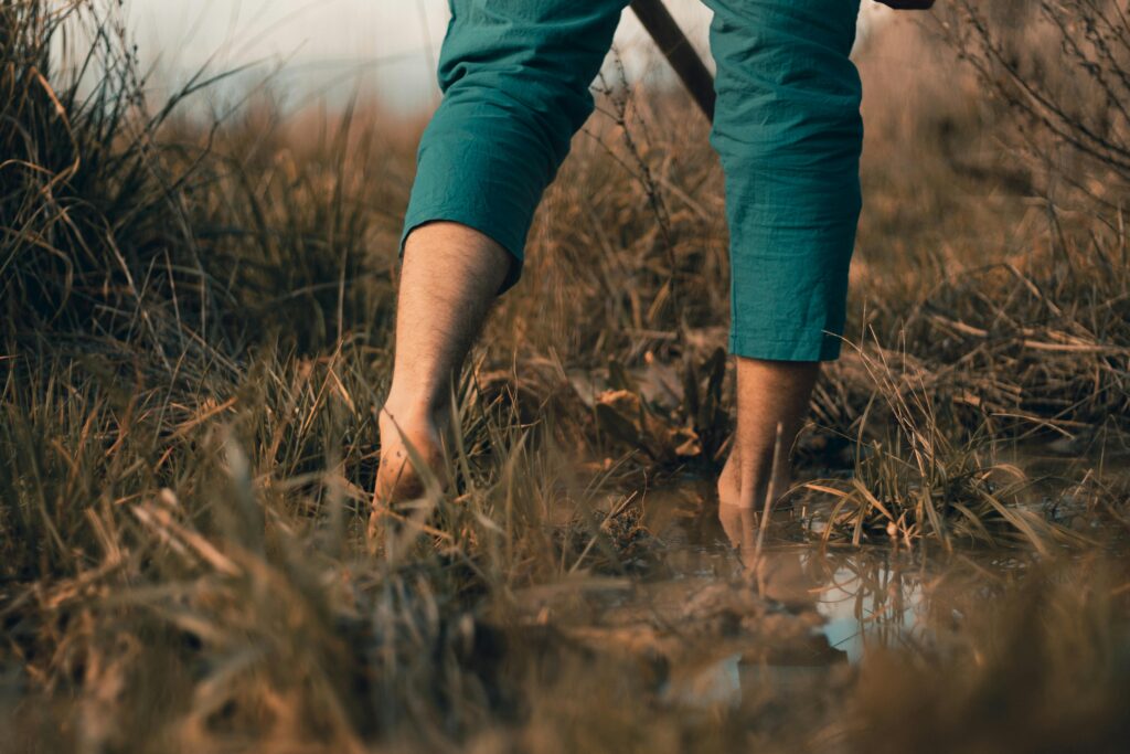 Blote voeten wandelend in de modder